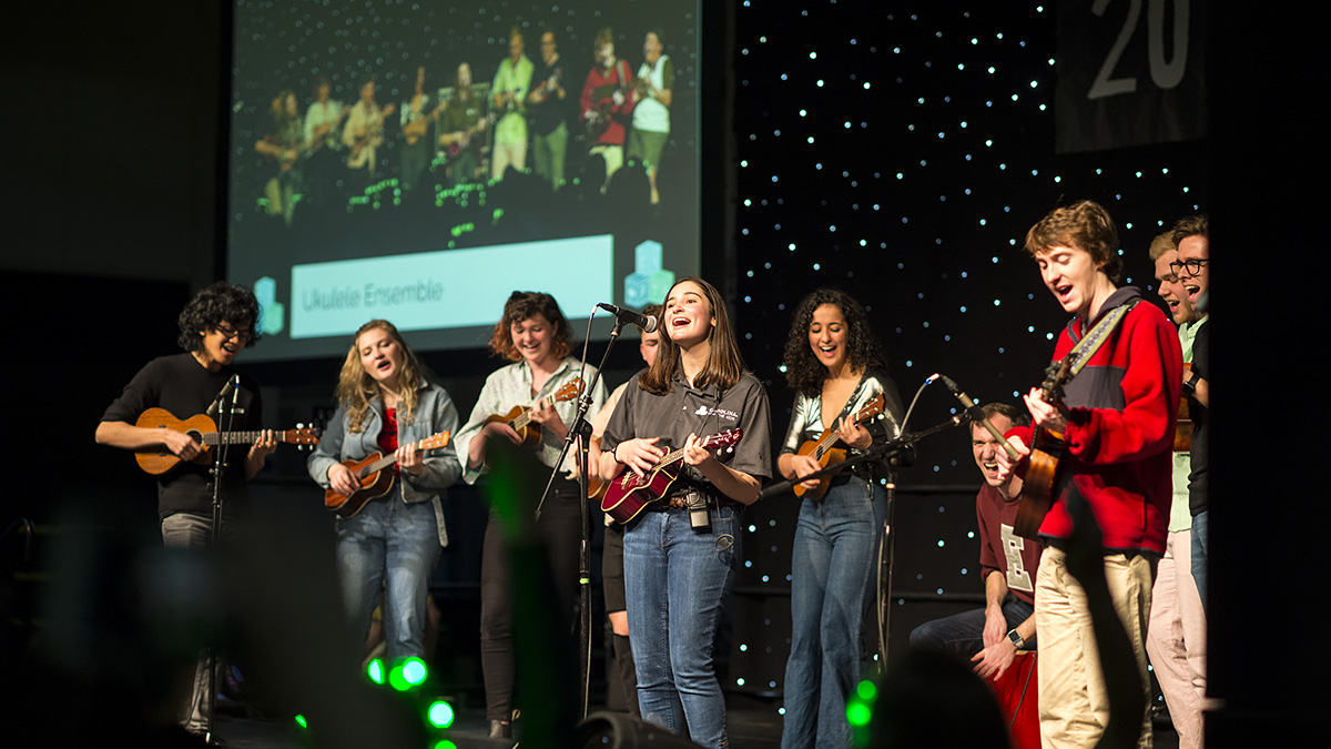 Students perform on stage with ukeleles.